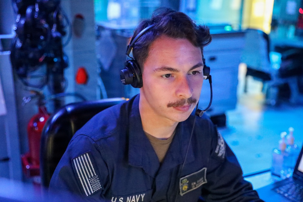 Sailors aboard the USS John Finn stand watch in the combat information center during Resolute Dragon 25 in the Philippine Sea