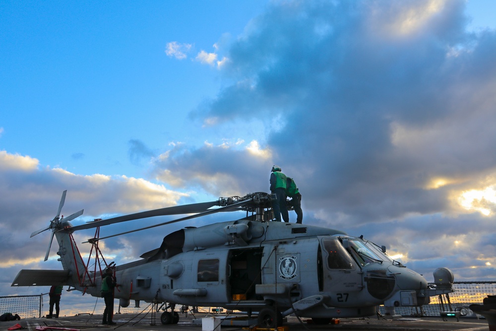 AEAN Bruce Wade and AE2 Paul Tran conduct post flight maintenance on an MH-60R Sea Hawk