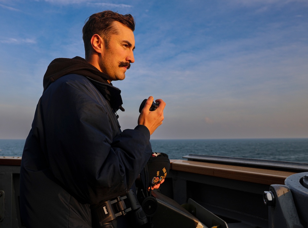 Ensign Joseph Wood provides contact bearing from the portside bridge wing