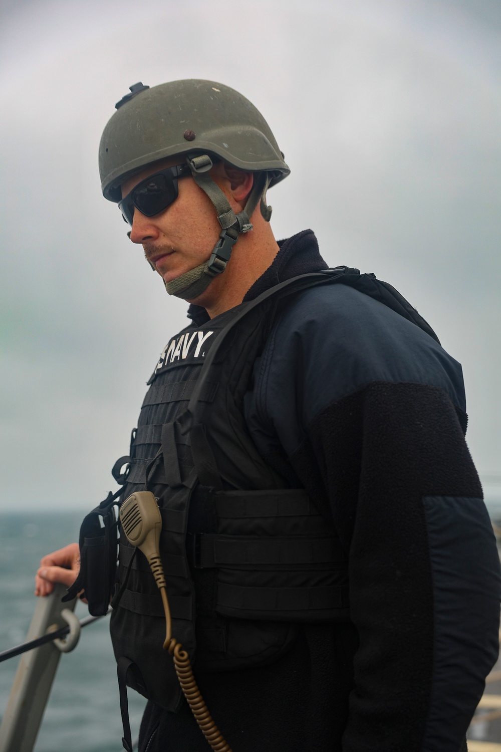 MA1 Corey Pilcher observes an approach of a pilot boat while providing roving security