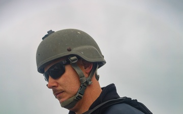 MA1 Corey Pilcher observes an approach of a pilot boat while providing roving security