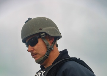 MA1 Corey Pilcher observes an approach of a pilot boat while providing roving security