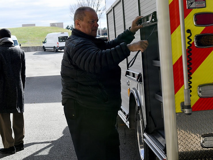 A rescue worker opens a rescue vehicle side compartment