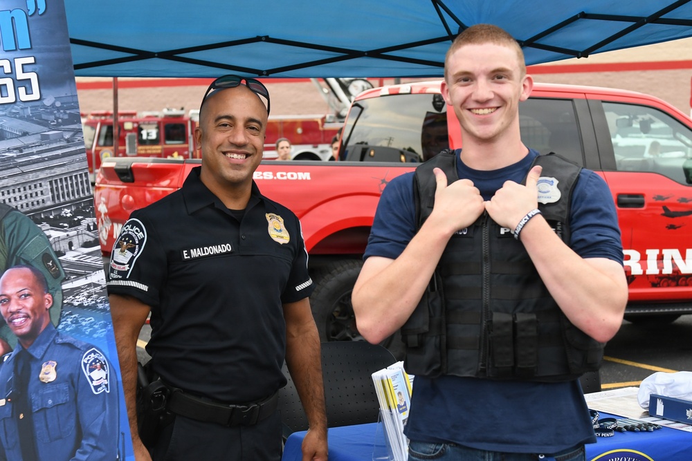 A Pentagon police officer talks with a job seeker at a job fair