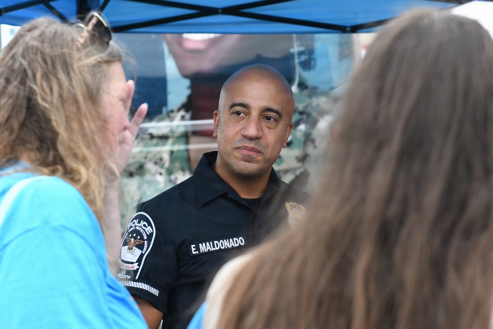 A Pentagon police officer talks with a job seekers at a job fair