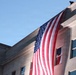An American flag hangs from the side of the Pentagon building