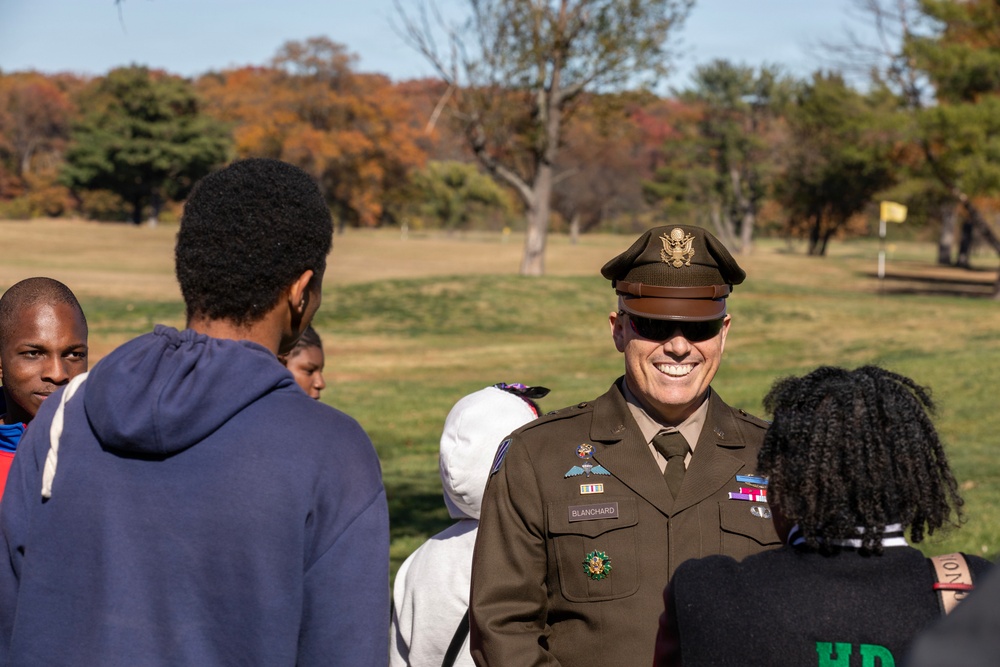 Brig. Gen. Leland D. Blanchard II speak with children participating in a Special Olympic program