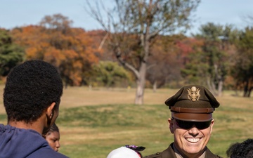 Brig. Gen. Leland D. Blanchard II speak with children participating in a Special Olympic program