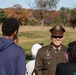 Brig. Gen. Leland D. Blanchard II speak with children participating in a Special Olympic program