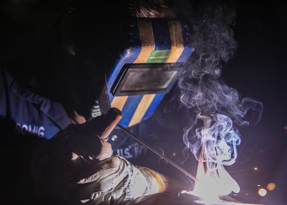 USS Mitscher (DDG 57) Sailor welds valve in ship's machine shop