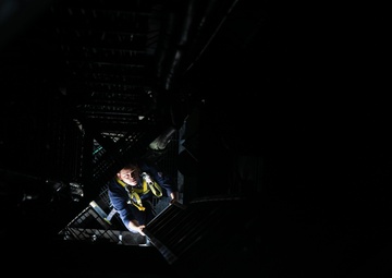 USS Mitscher (DDG 57) Sailor climbs ship interior mast