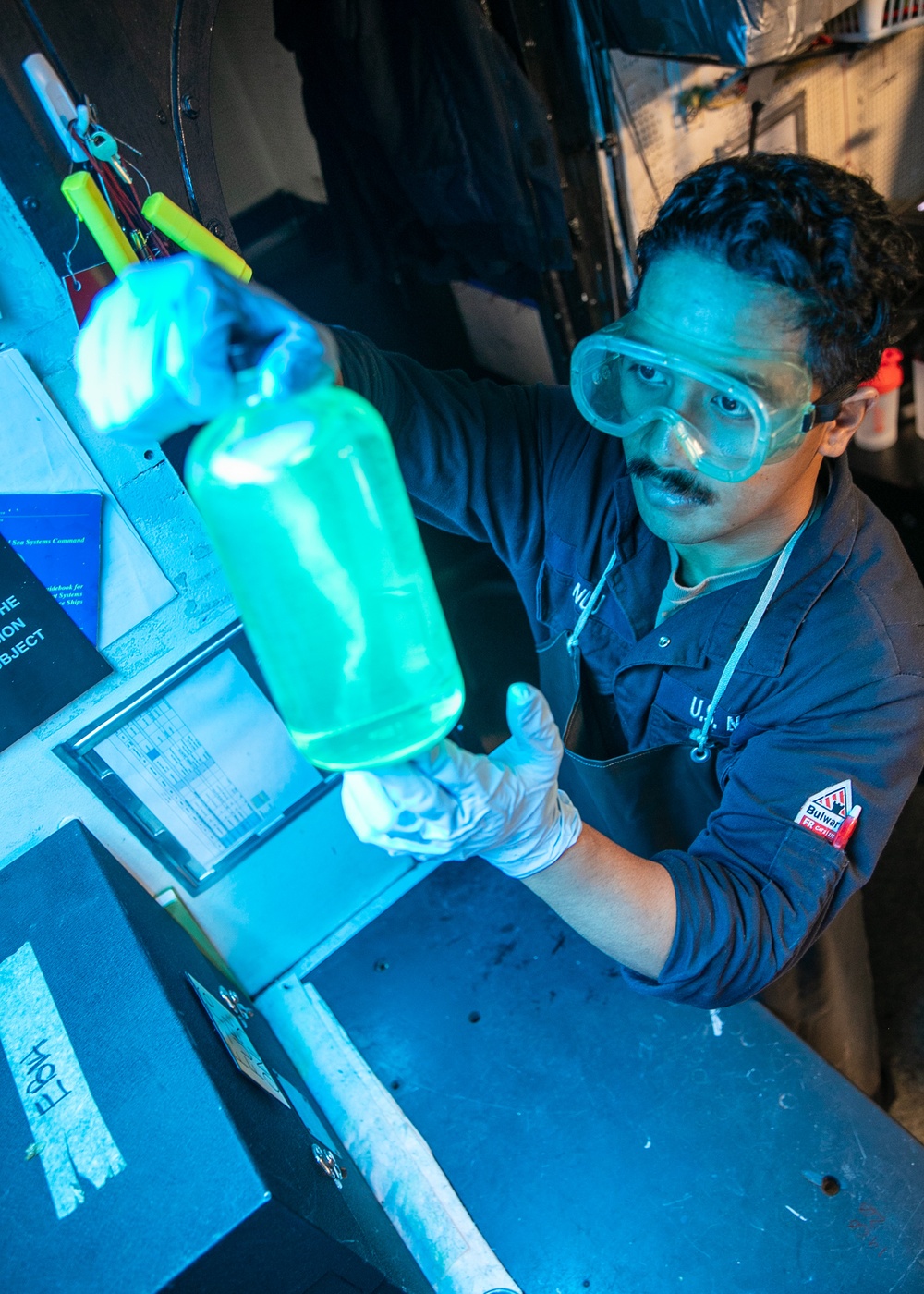 USS Mitscher (DDG 57) Sailor inspects fuel sample in oil laboratory
