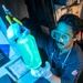 USS Mitscher (DDG 57) Sailor inspects fuel sample in oil laboratory