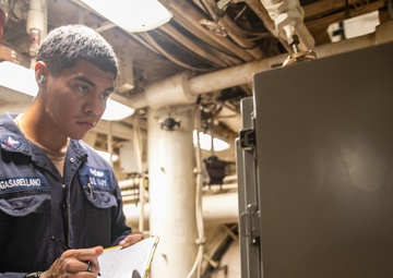 USS Mitscher (DDG 57) Sailor takes readings in engine room