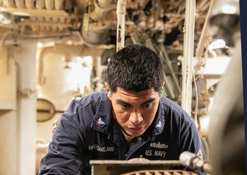 USS Mitscher (DDG 57) Sailor takes readings in engine room