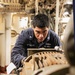 USS Mitscher (DDG 57) Sailor takes readings in engine room