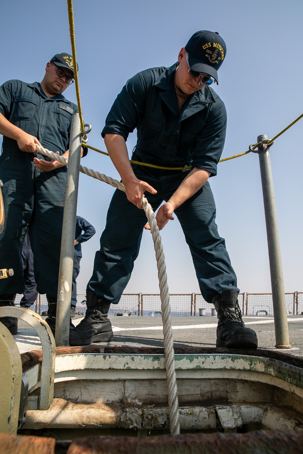 USS Mitscher (DDG 57) Sailor lowers mooring line