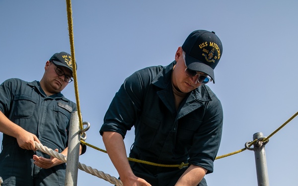 USS Mitscher (DDG 57) Sailor lowers mooring line