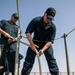 USS Mitscher (DDG 57) Sailor lowers mooring line