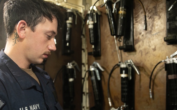 USS Mitscher (DDG 57) Sailor inspects HAZMAT in storage locker