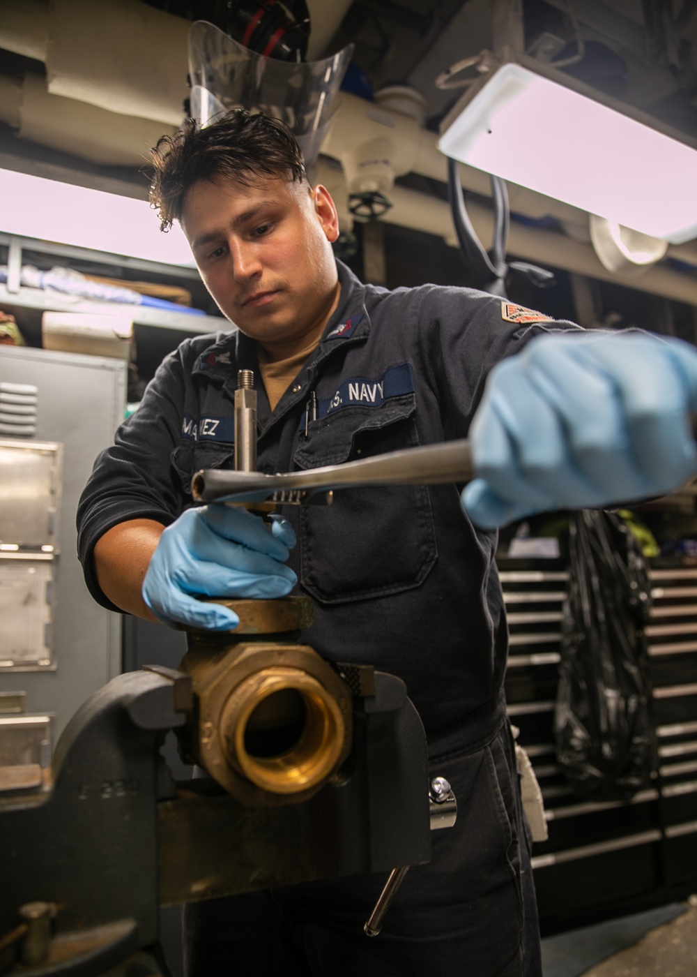 USS Mitscher (DDG 57) Sailor conducts maintenance on valve