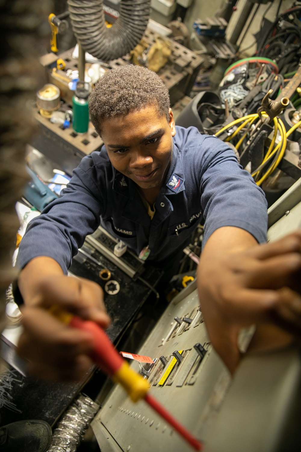USS Mitscher (DDG 57) Sailor secures fuse panel