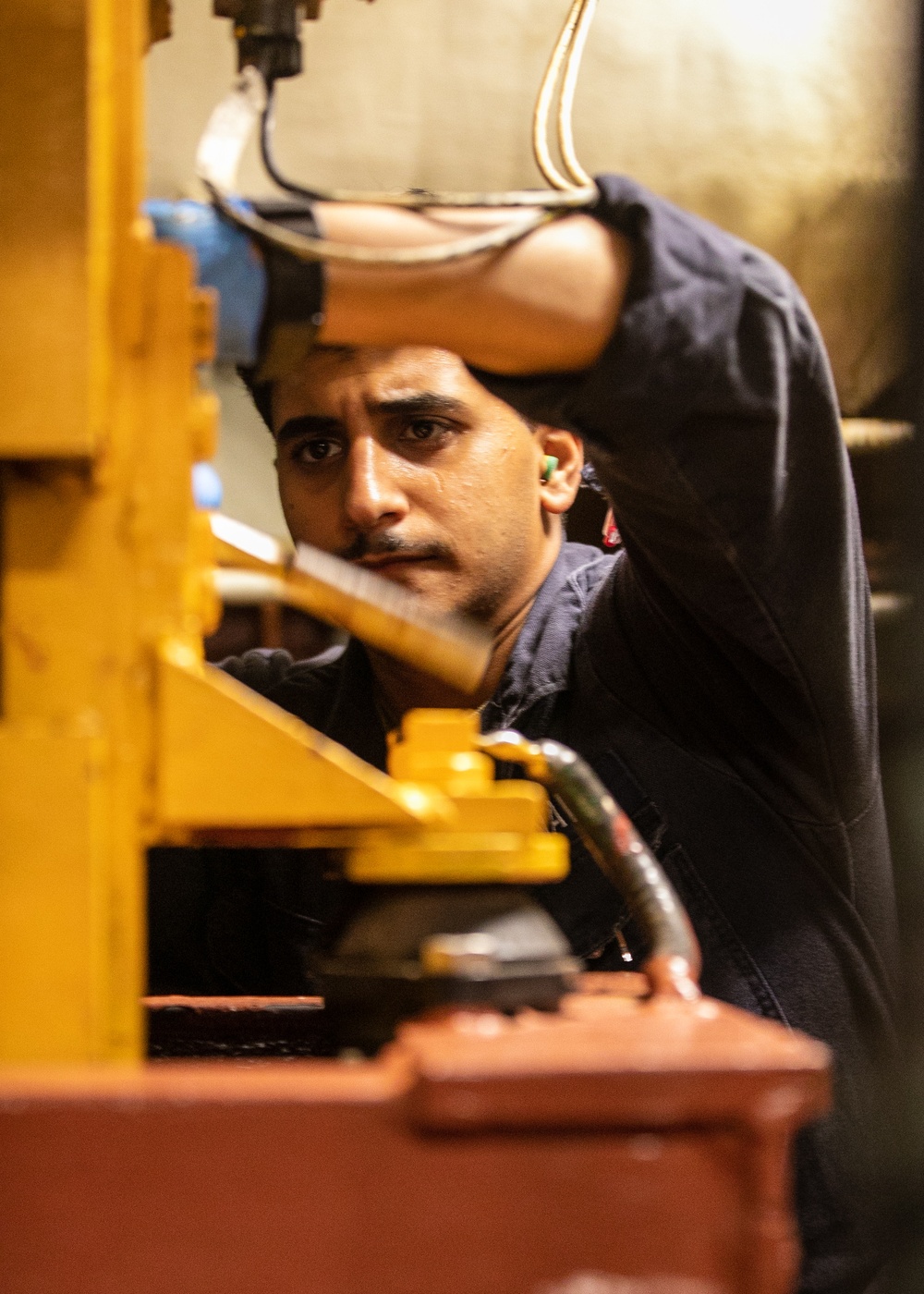 USS Mitscher (DDG 57) Sailor conducts maintenance in engine room