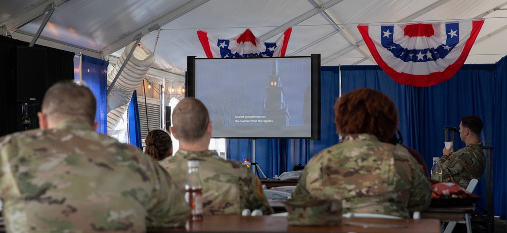 Service Member and civilians watch documentary on Revolutionary War