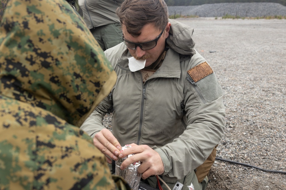 U.S. Marine explosive ordnance disposal technicians execute an experimental demolition range