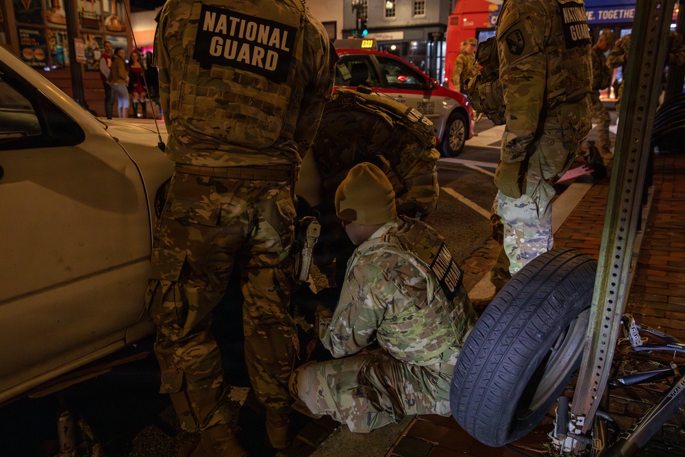 Joint Task Force Magnolia Soldiers change a tire on Halloween