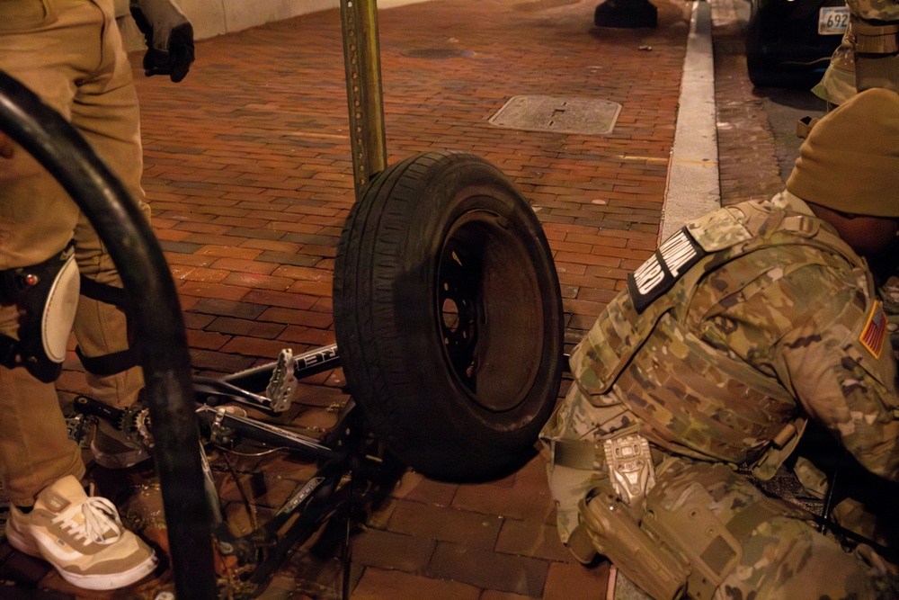 Joint Task Force Magnolia Soldiers change a tire on Halloween