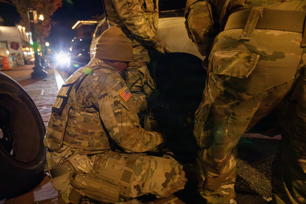 Joint Task Force Magnolia Soldiers change a tire on Halloween