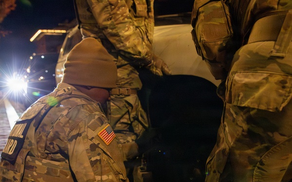 Joint Task Force Magnolia Soldiers change a tire on Halloween