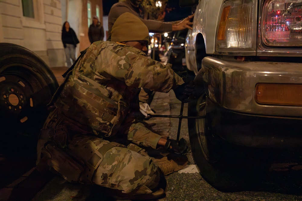A Mississippi Army National Guard Soldier changes a tire on Halloween