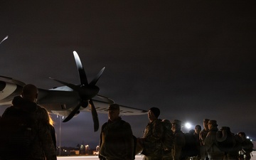 Soldiers of the 147th Army Band, South Dakota Army National Guard, wait to board a Kentucky Air National Guard C-130J Super Hercules