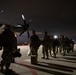 Soldiers of the 147th Army Band, South Dakota Army National Guard, wait to board a Kentucky Air National Guard C-130J Super Hercules