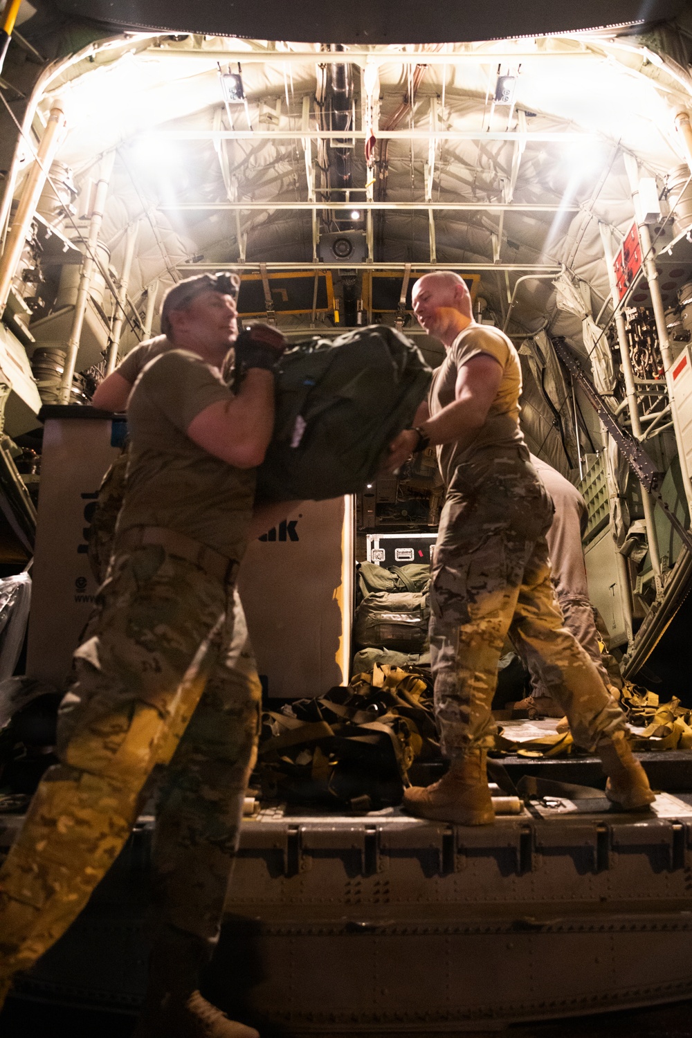 147th Army Band, South Dakota Army National Guard soldiers unload their equipment from a Kentucky Air National Guard C-130J Super Hercules