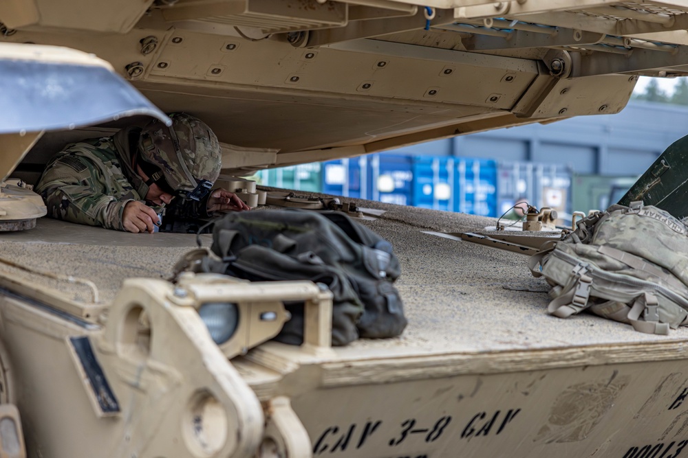 U.S. Army Soldier climbs into the driver's seat of an M1 Abrams