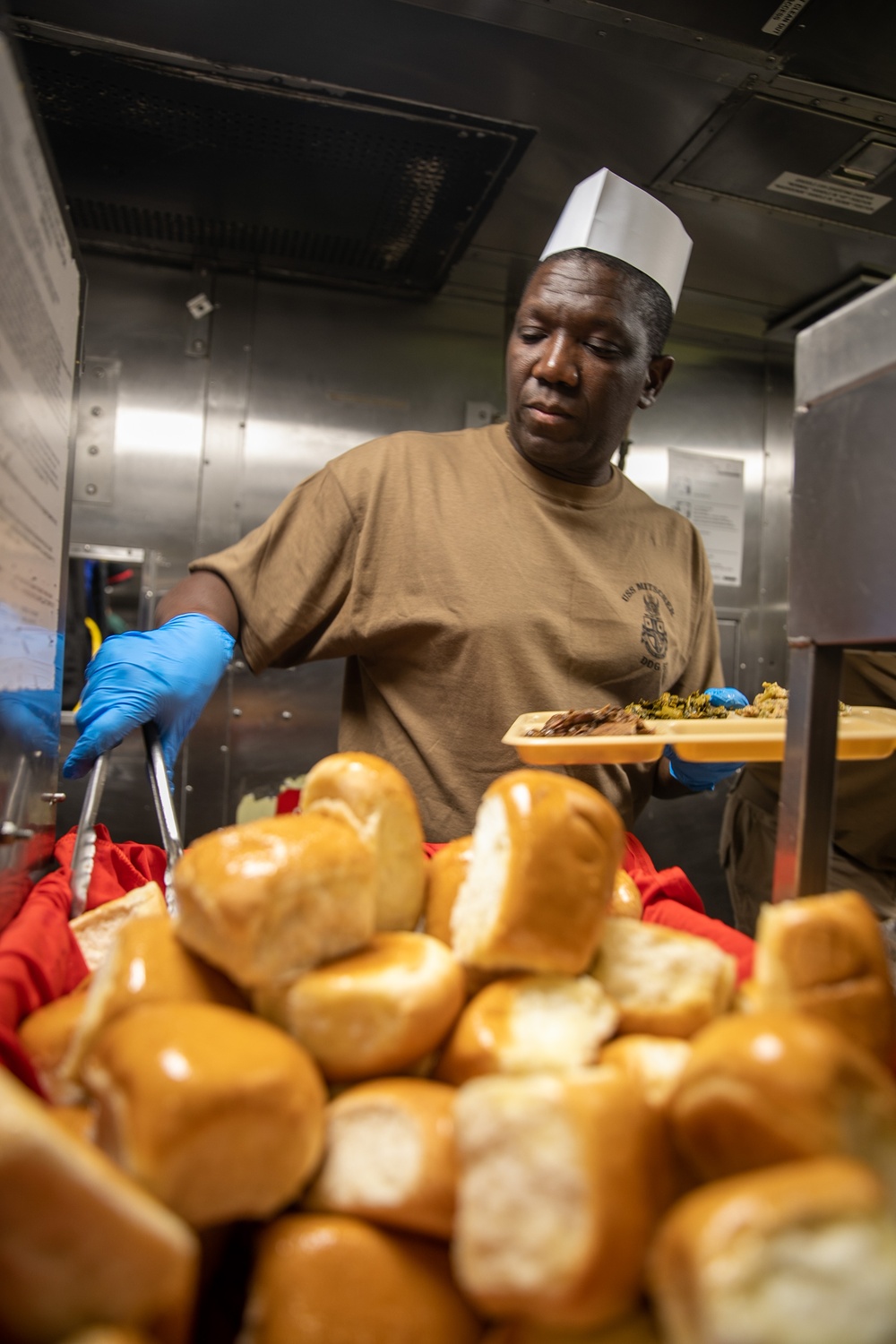 USS Mitscher (DDG 57) Sailor serves Thanksgiving meal