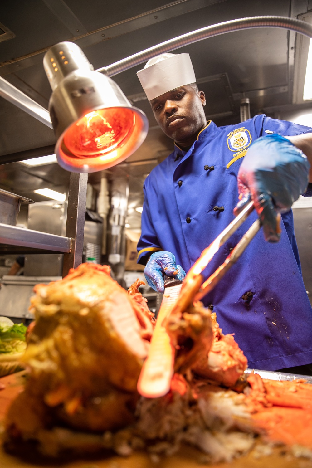 USS Mitscher (DDG 57) Sailor carves Thanksgiving turkey