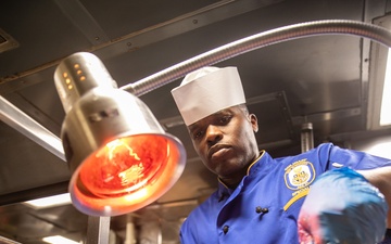 USS Mitscher (DDG 57) Sailor carves Thanksgiving turkey