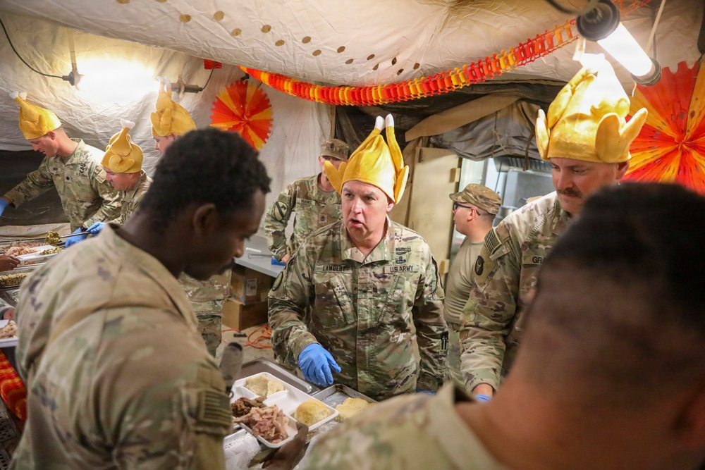 Brig. Gen. Kevin J. Lambert serves food to soldiers