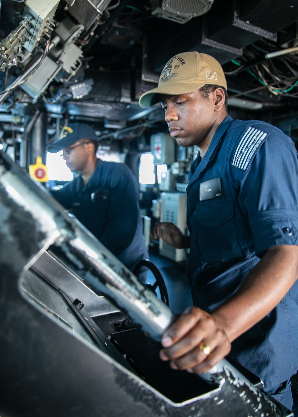 USS Mitscher (DDG 57) Sailor mans helm in ship bridge
