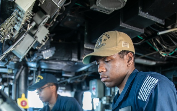USS Mitscher (DDG 57) Sailor mans helm in ship bridge