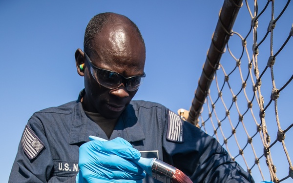 USS Mitscher (DDG 57) Seaman paints primer on flight deck