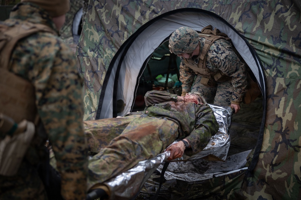 U.S. Navy Sailors alongside Finnish service members execute a simulated mass casualty response