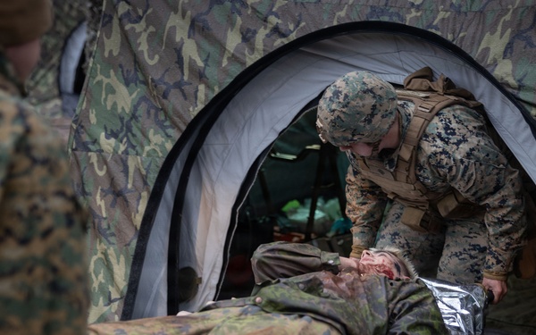 U.S. Navy Sailors alongside Finnish service members execute a simulated mass casualty response