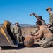 Airmen from the 377th Explosive Ordnance Disposal Flight guide a recovered training munition toward heavy equipment for relocation during a clearance mission on the Pueblo of Isleta, N.M.