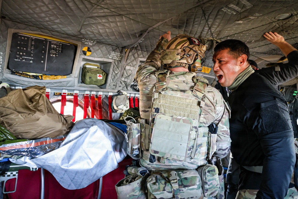 Medical Officer Guides SOF Civil Affairs Soldier Conducting Critical Combat Casualty Care in a Recent Combined Arms Field Exercise with a 82nd Airborne CH-47 Chinook Crew