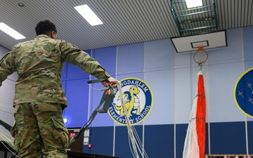 Aircrew flight equipment technicians introduce elementary students to motion, matter with parachutes